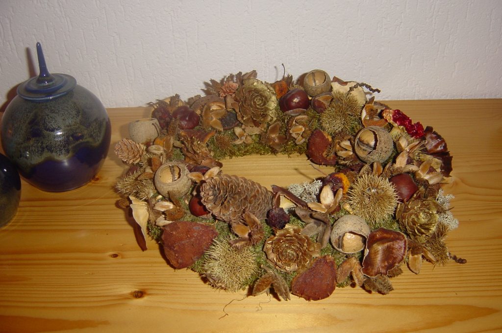 Atelier thuis, Herfstkrans gemaakt van kastanjes, appeltjes en zaaddozen die in de herfst in het bos gezocht zijn.