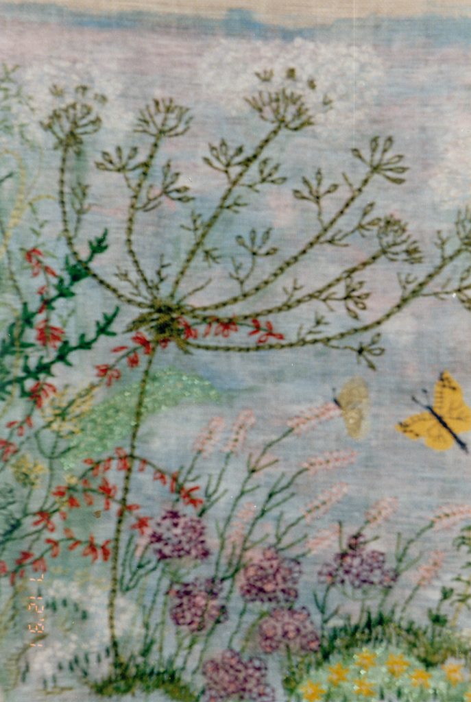 EEN BLOEMENIMPRESSIE Free Style. Ondergrond kaaslinnen met textielverf en borduurgarens van dik naar dun. Ontwerp: Van tekeningen nagemaakt. Kaaslinnen werkt minder prettig omdat het de textielverf niet goed opneemt. Het materiaal wat verder gebruikt is, is wat grover en dikker. Het werkt sneller en met een mooi resultaat. Het eerste wandkleed in portret opstelling.