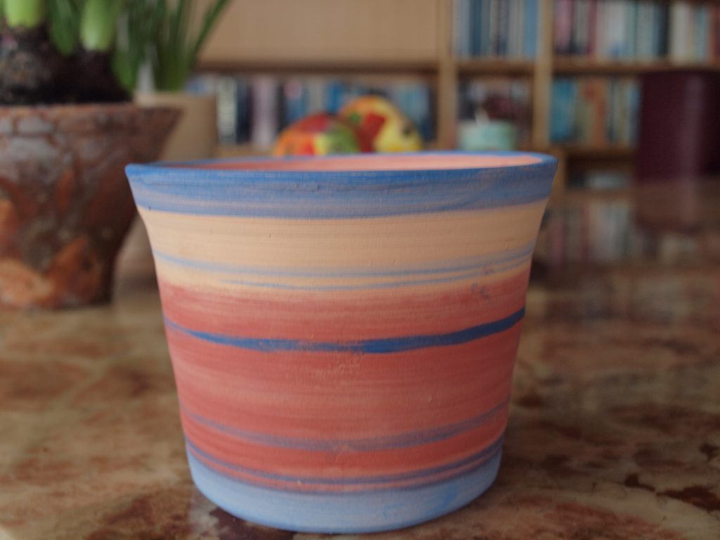 Pot, gedraaid, leerkleurige klei. Bewerkt met kleurpigmenten, gestookt 1060° C.